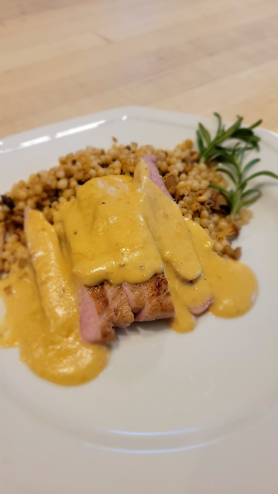 SALMON CREEK PORK RIBEYE STEAK WITH HUCKLEBERRY CHEDDAR CHEESE SAUCE AND COUSCOUS